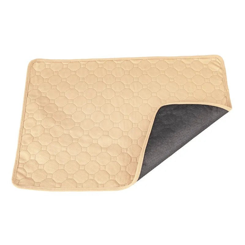 Grey and khaki washable waterproof dog pee pad on a wooden floor next to a pet crate.