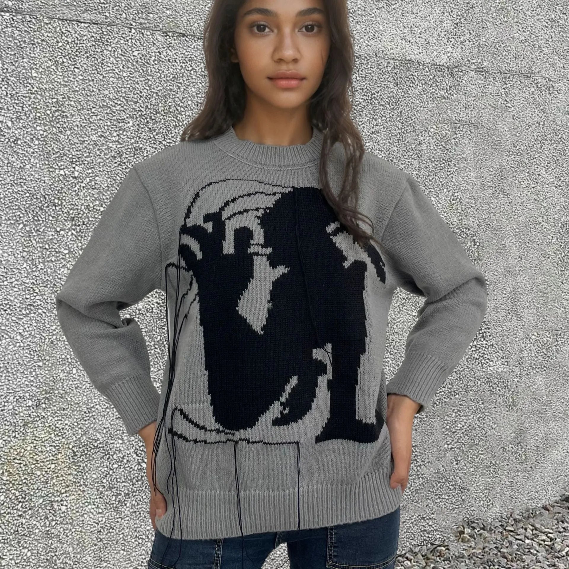 Women's grey alpaca wool sweater with tassel detailing and round neck.