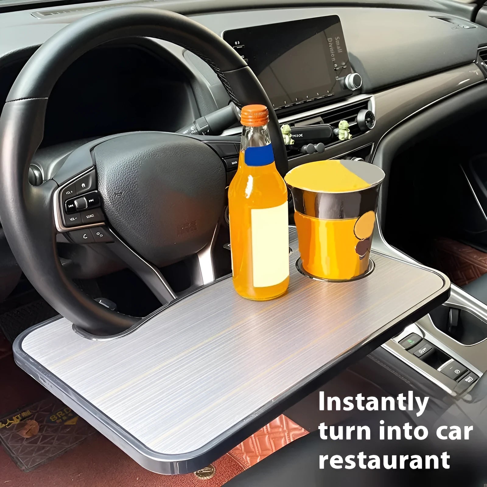 Black foldable ABS plastic tray positioned on a car steering wheel, shown with a laptop and foldable cup holder.
