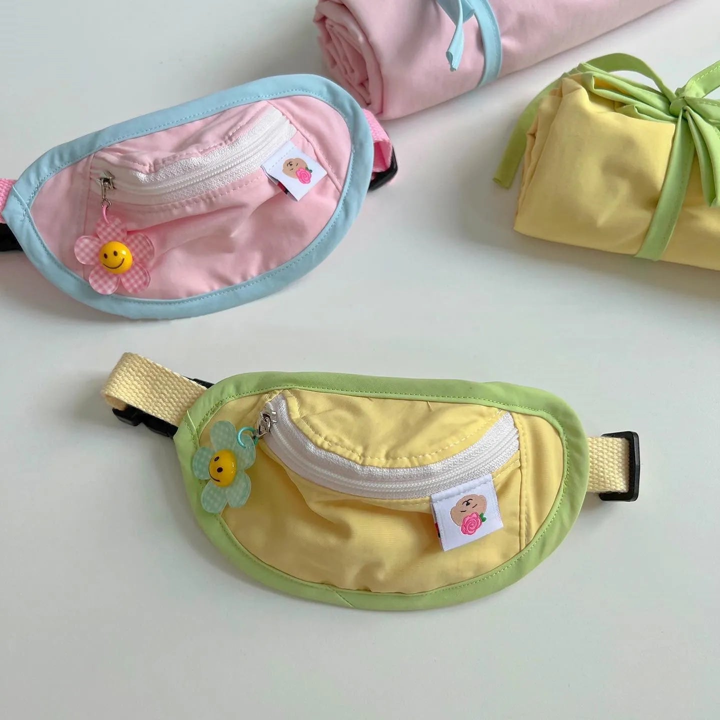 Pink and yellow messenger bag-style pet backpack carrier for small dogs and cats showing adjustable straps
