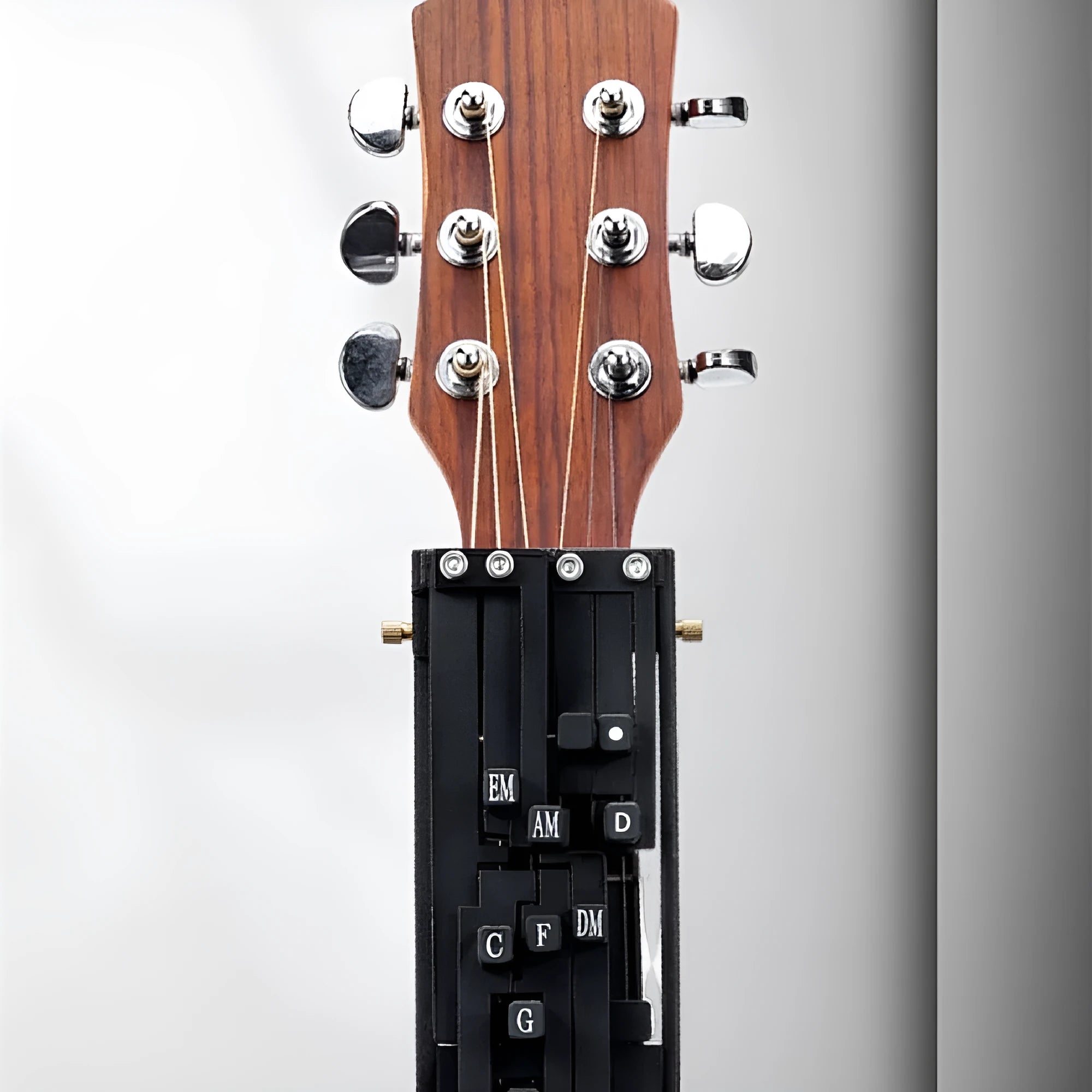 Automatic chord practice device for folk guitar, shown in black, designed for novice second chord training.