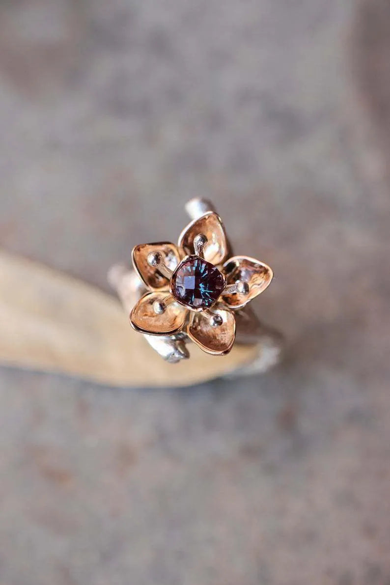 Silver coloured women's alloy ring with geometric shape and two-tone floral design on a white background.