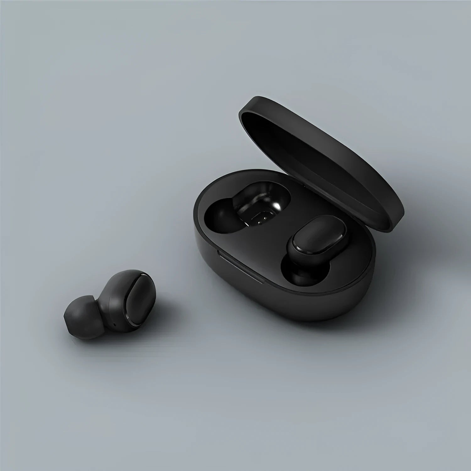 Redmi AirDots black true wireless earbuds next to their white charging case.