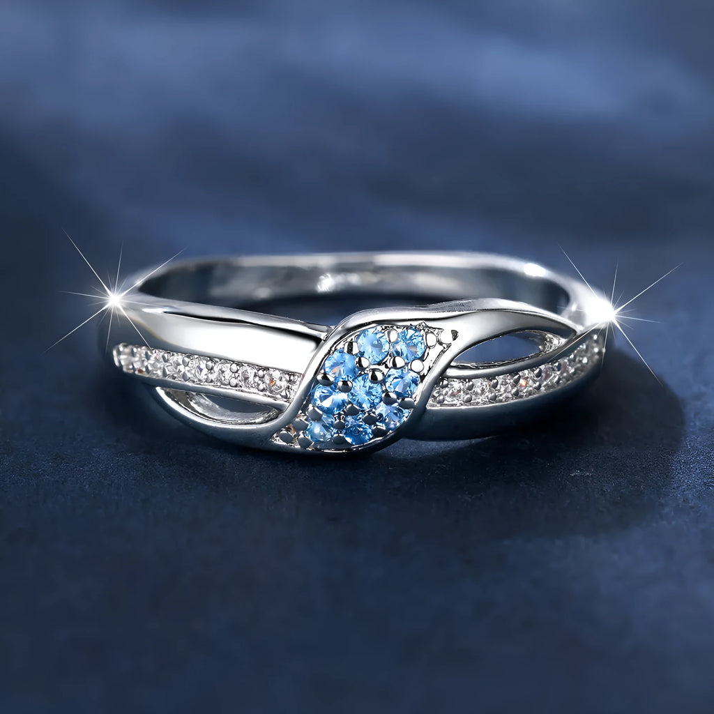 Women's ring with sea blue diamond edge inlay and white diamond leaf accents on white K plated copper band, simple geometric style