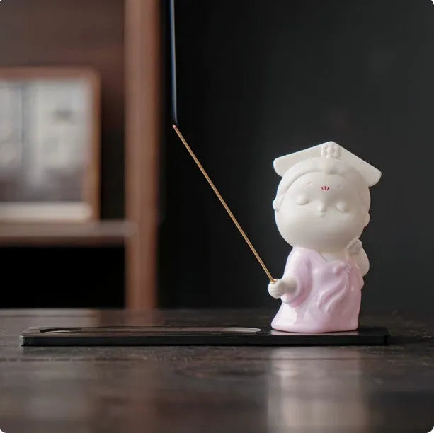 Ceramic cute female court attendant figurine incense burner decoration on a surface.