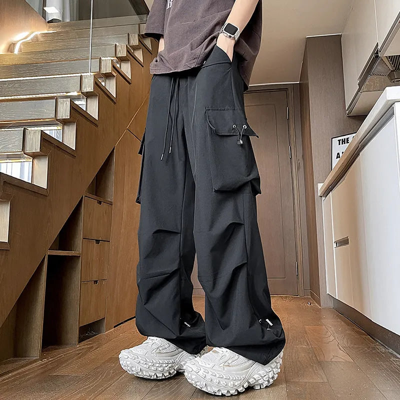 Women's plus size straight-leg waterproof trousers in black, showing drawstring waist and loose fit.