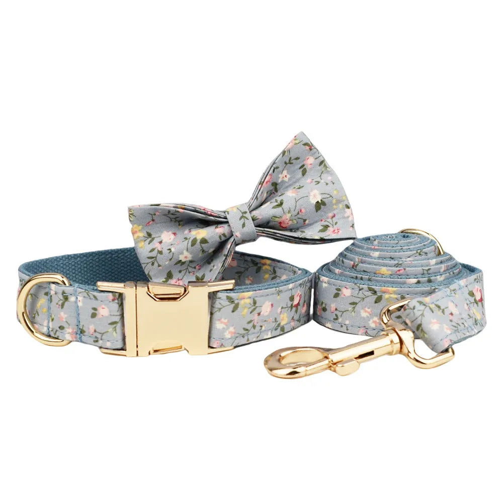 Blue floral patterned cloth dog collar and leash set with matching vest and bow accessories.