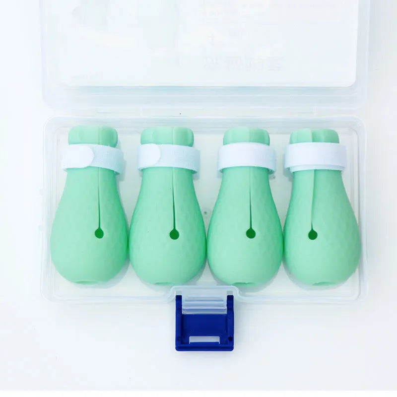 Four green silicone cat paw scratch protection covers with elastic straps