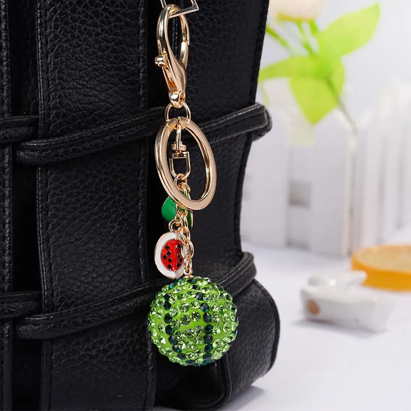 Green zinc alloy watermelon keychain measuring 12 cm in length.