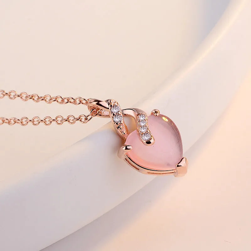 Women's heart-shaped pink crystal pendant with rose gold electroplated finish and matching cross chain