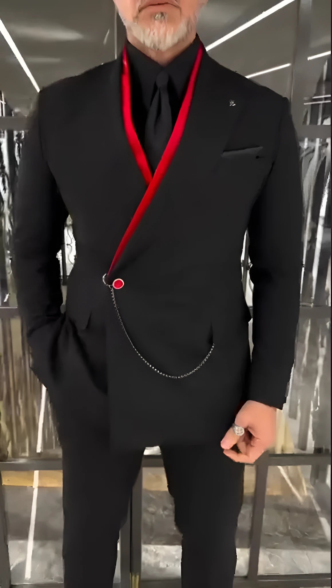 Black fake double-layered jacket with red interior and front chain detail worn casually