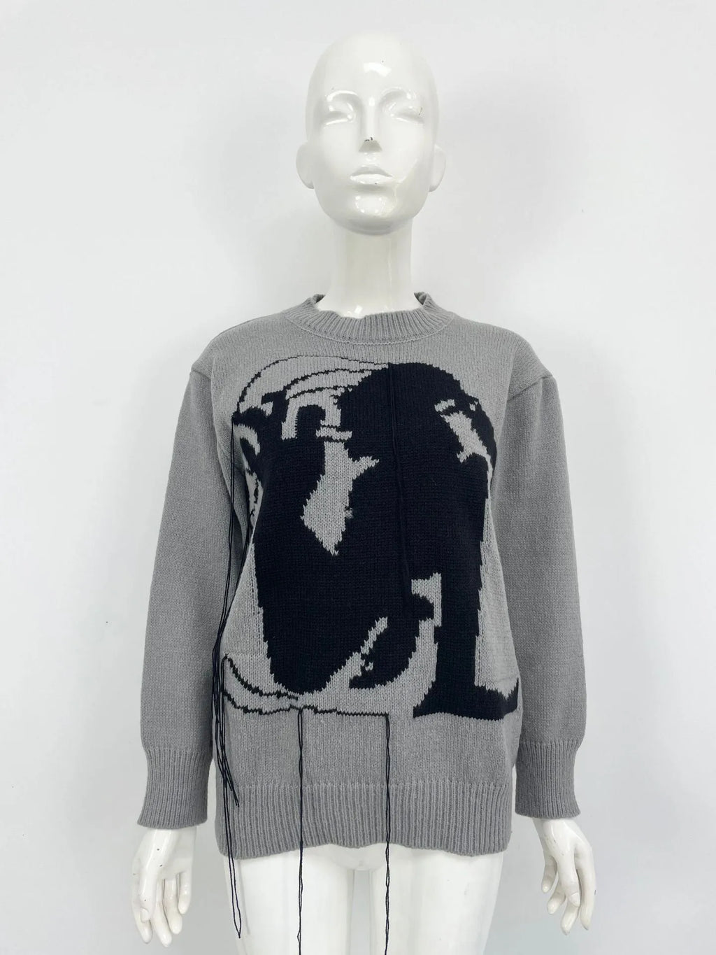 Women's grey alpaca wool sweater with tassel detailing and round neck.