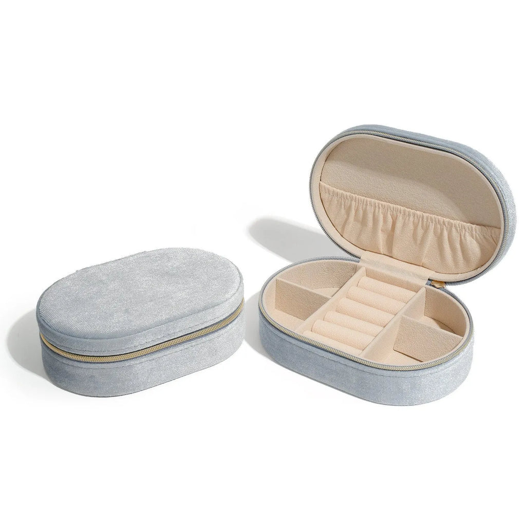 Oval velvet jewellery box with handle in lake blue colour, showing flannel-lined interior.