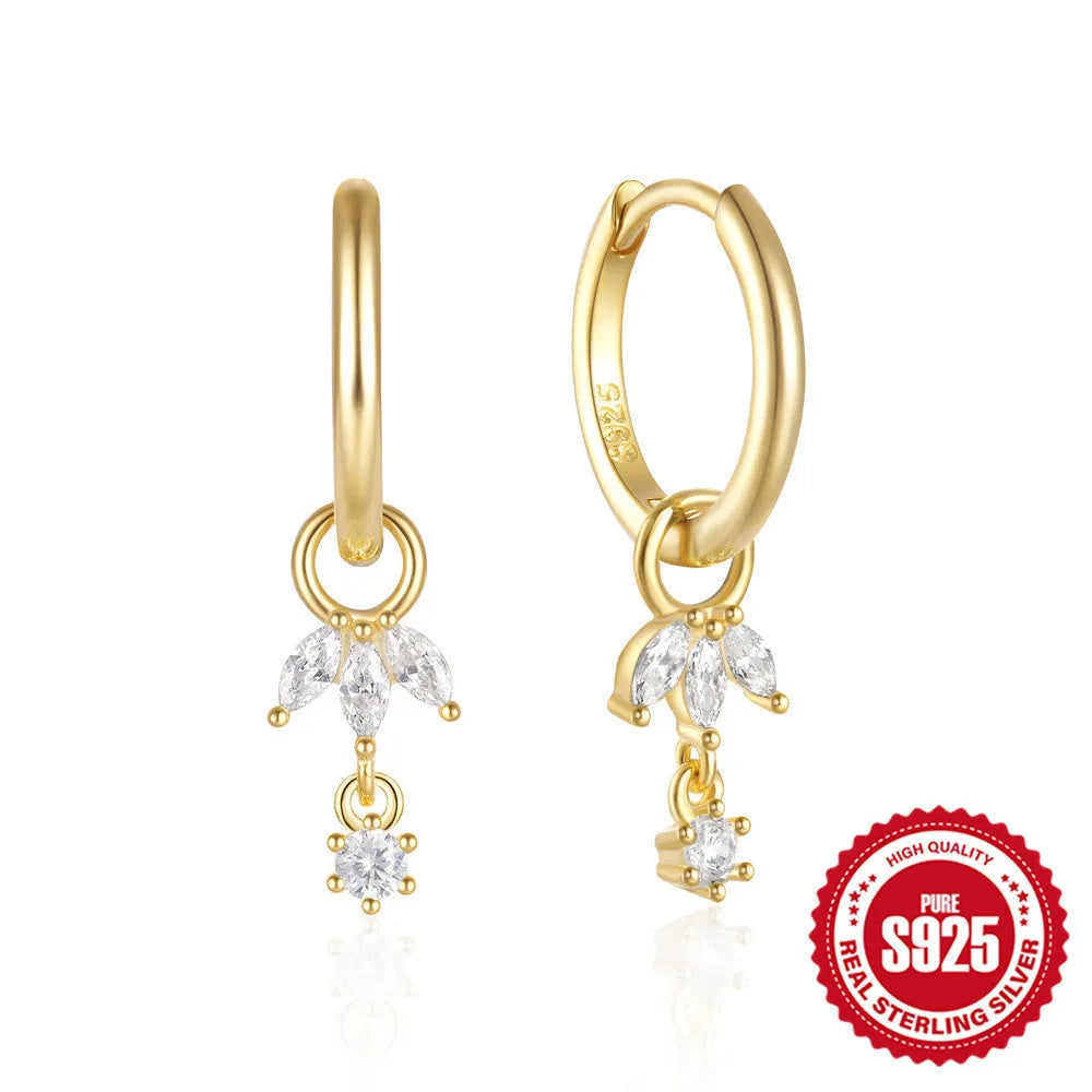 Close-up of geometric sunflower design sterling silver earrings with golden zircon stones.