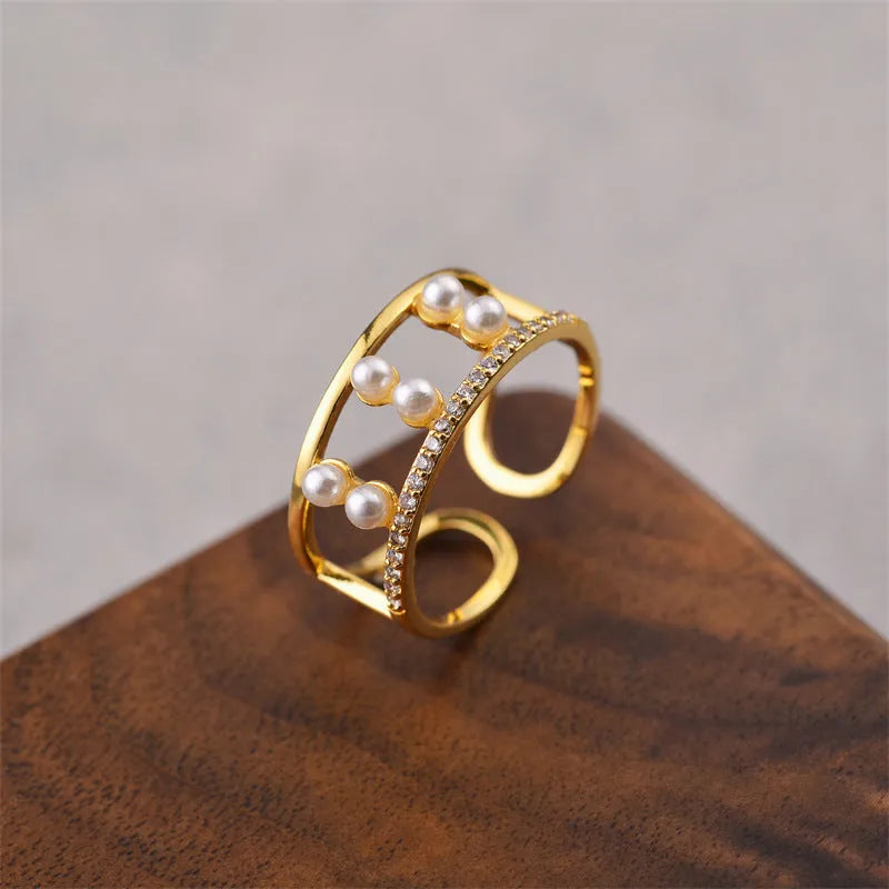 Gold geometric open ring for women on a grey background.