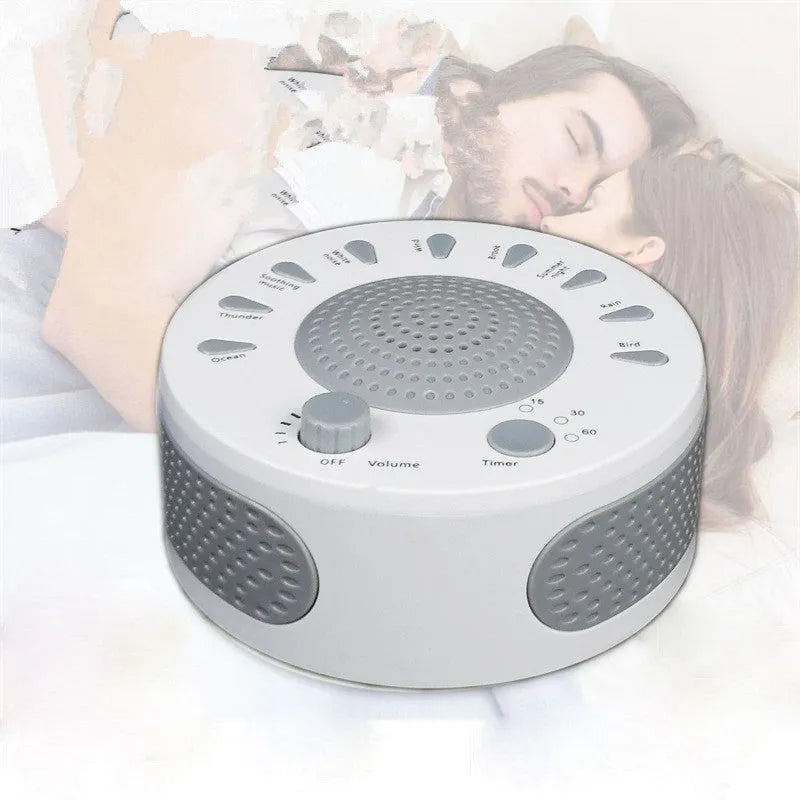White portable white noise sleep sound machine with control knob on a bedside table.