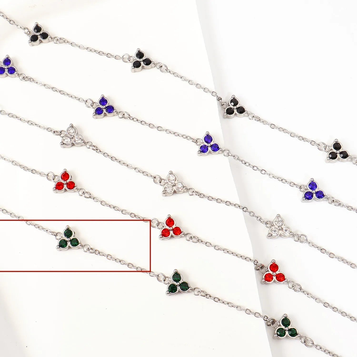 Women's stainless steel geometric bracelet with triangle design and three-diamond centrepiece in gold or steel finish.
