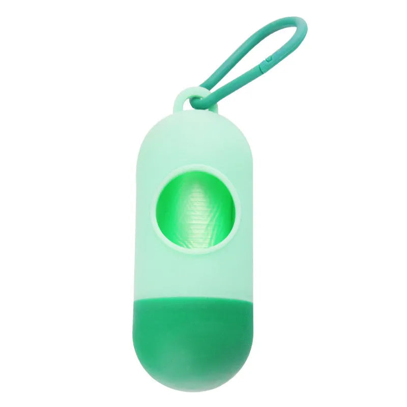 Black plastic dog poop bag holder with a metal side hook and Velcro strap, showing compact size.