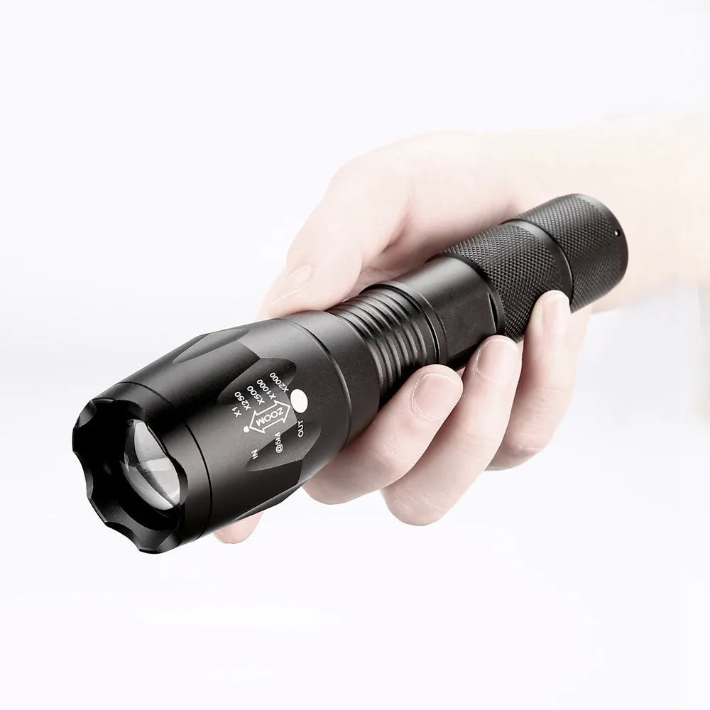Black aluminium alloy zoomable LED flashlight with adjustable focus ring on a textured body.