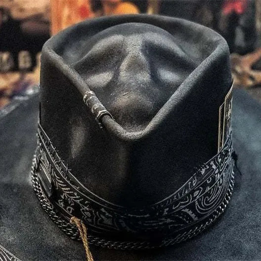Handmade black skull hat with conical crown, made from wool and denim fabric, on a neutral background.