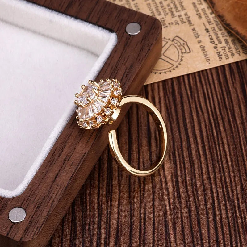 Gold electroplated copper flower ring with open mouth design on a plain background