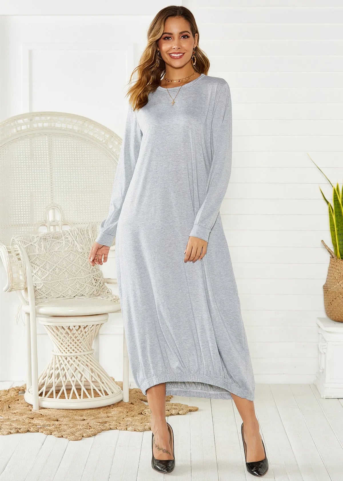 Loose-fitting black lantern dress with a crew neck and lace-up front detail on a mannequin.