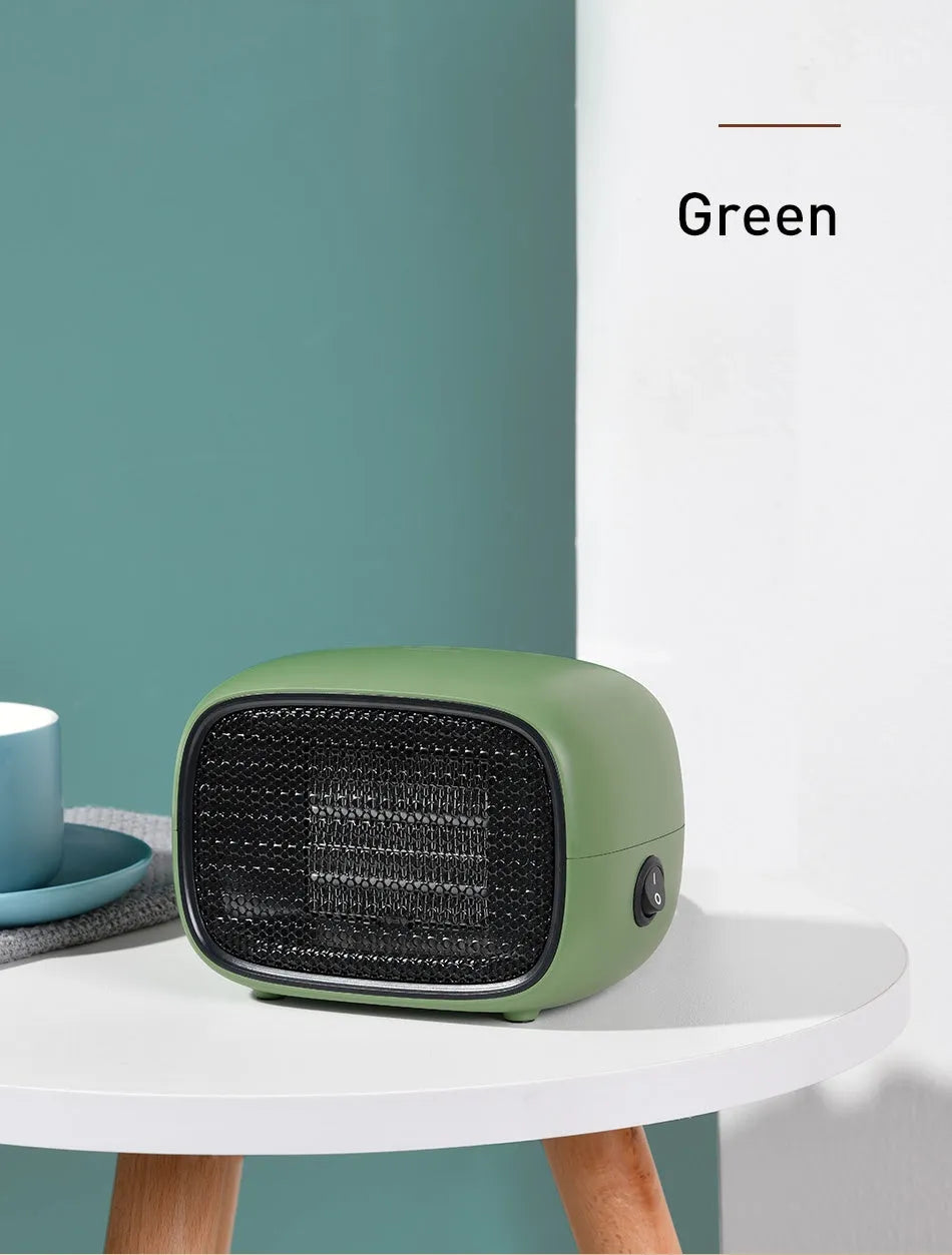 Compact green mini ceramic heater with metal mesh front on a wooden desk