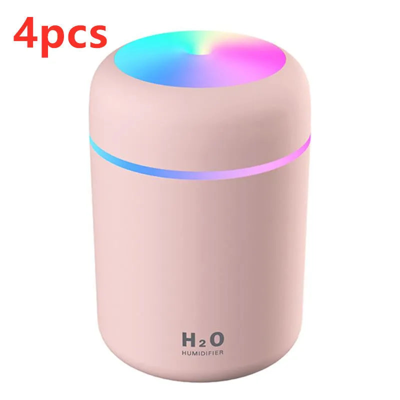 Pink USB desktop humidifier with colourful LED lights and 300ml water tank on wooden desk