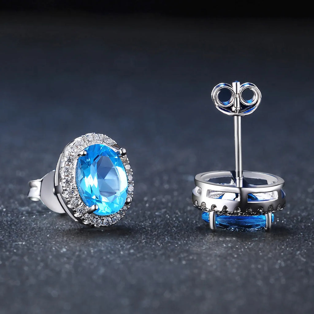 Women's 925 silver blue topaz jewellery set showing geometric earrings, ring, pendant and necklace.