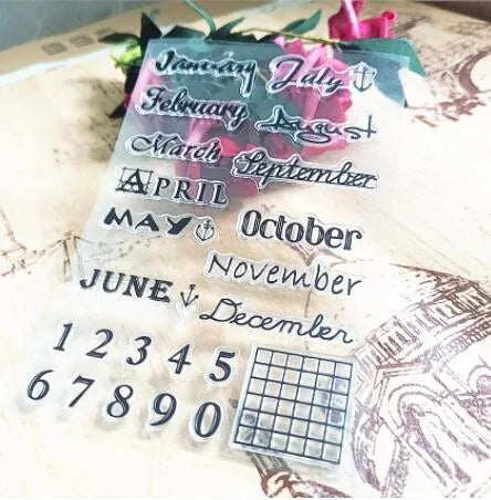 Close-up of a transparent silicone craft stamp featuring vintage-style calendar icons on a digital table background.