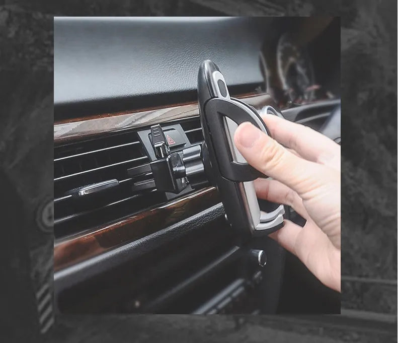 Black universal mobile phone holder attached to a car air conditioning vent.
