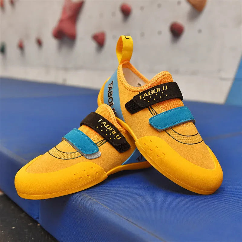 A pair of black and red rock climbing shoes with Velcro straps and a rubber sole.