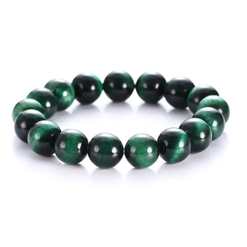 Green tiger eye stone bracelet with polished geometry beads and a sliding knot closure on a wrist.