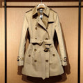 Khaki women's double-breasted trench coat with long sleeves and button fastenings.