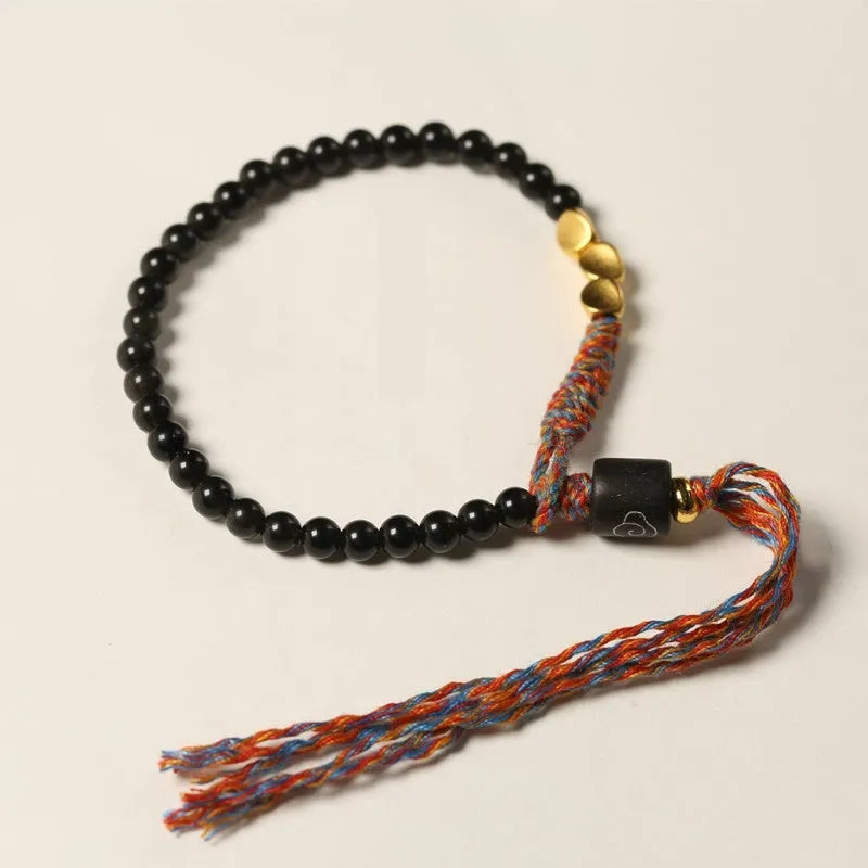 Hand-woven obsidian carrying strap bracelet showing textured weave detail and narrow 4mm width