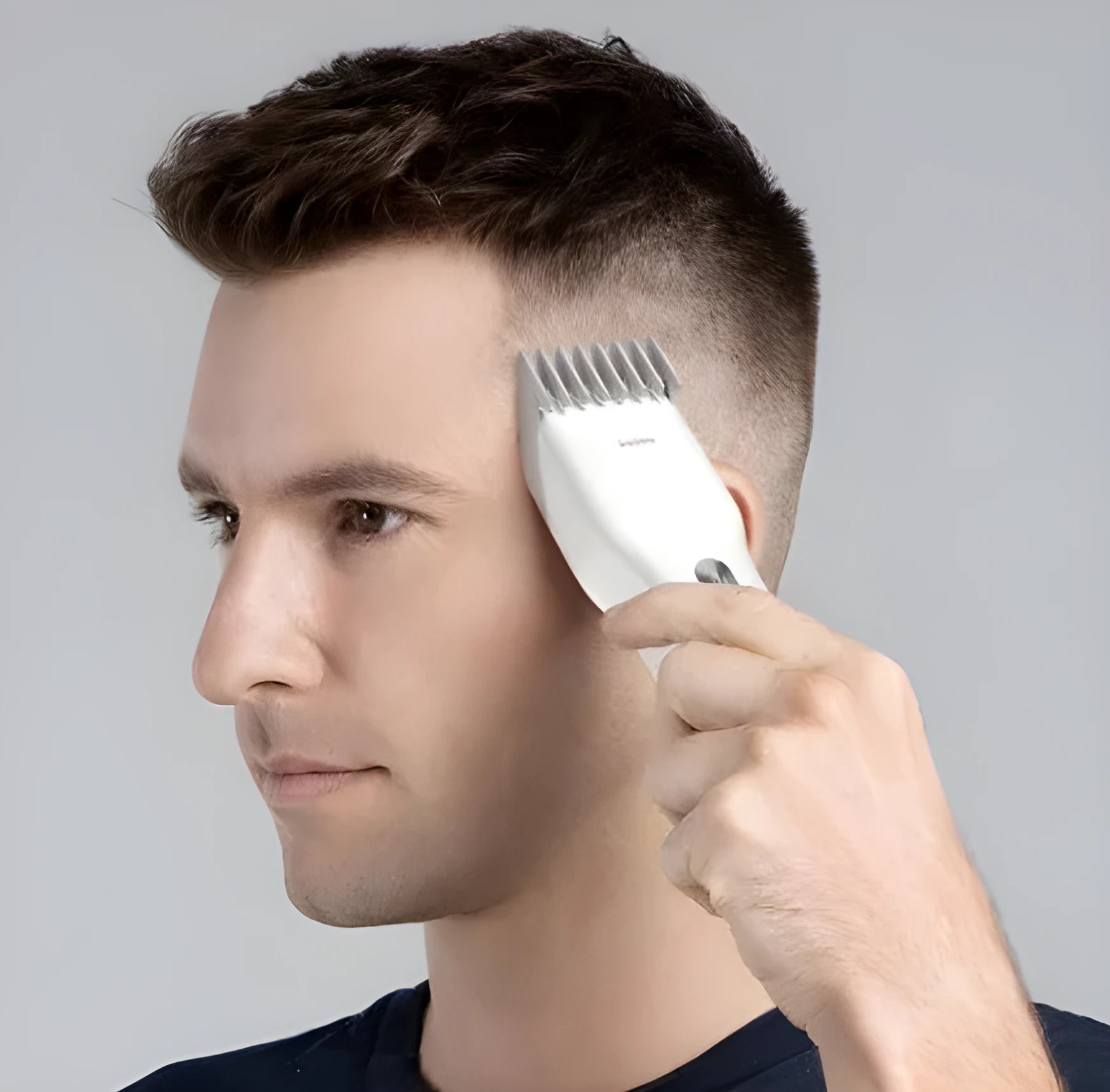Black cordless electric hair clipper with adjustable length comb and ceramic cutter head on a white background