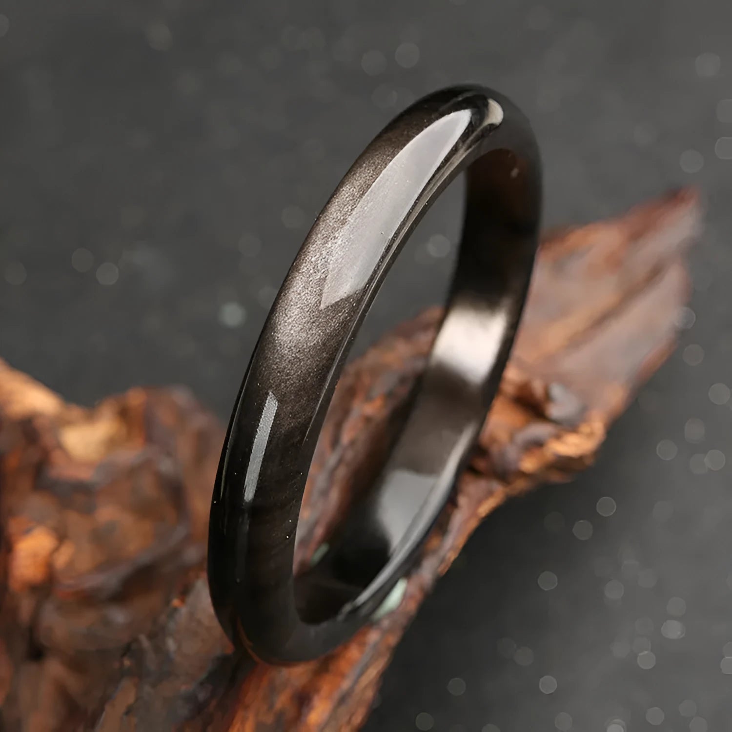 Natural silver stone cat's eye obsidian and alloy ethnic bracelet with geometric patterns on a wrist.