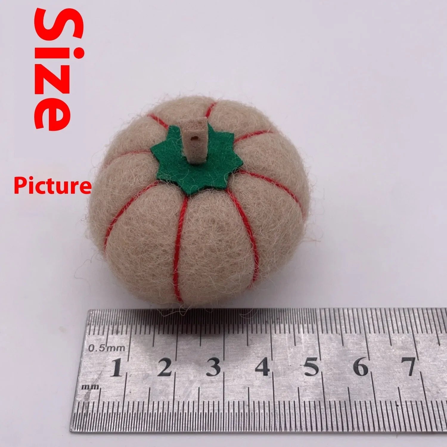 Wool felt pumpkin-shaped doll decorations in autumn colours on a neutral background