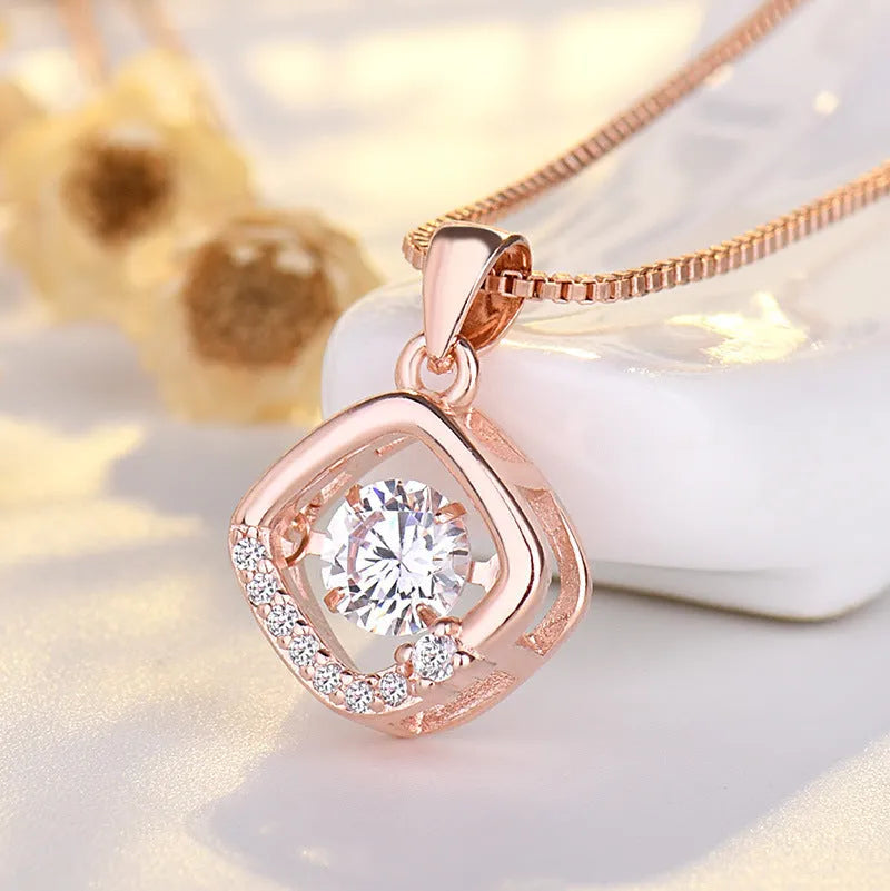 Silver heart pendant necklace with small crown and bow charms on a delicate chain.