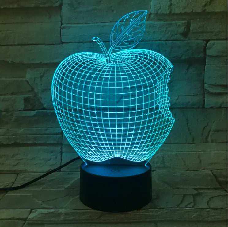 3D fruit-shaped colourful night light with acrylic shade and touch control on a dark surface