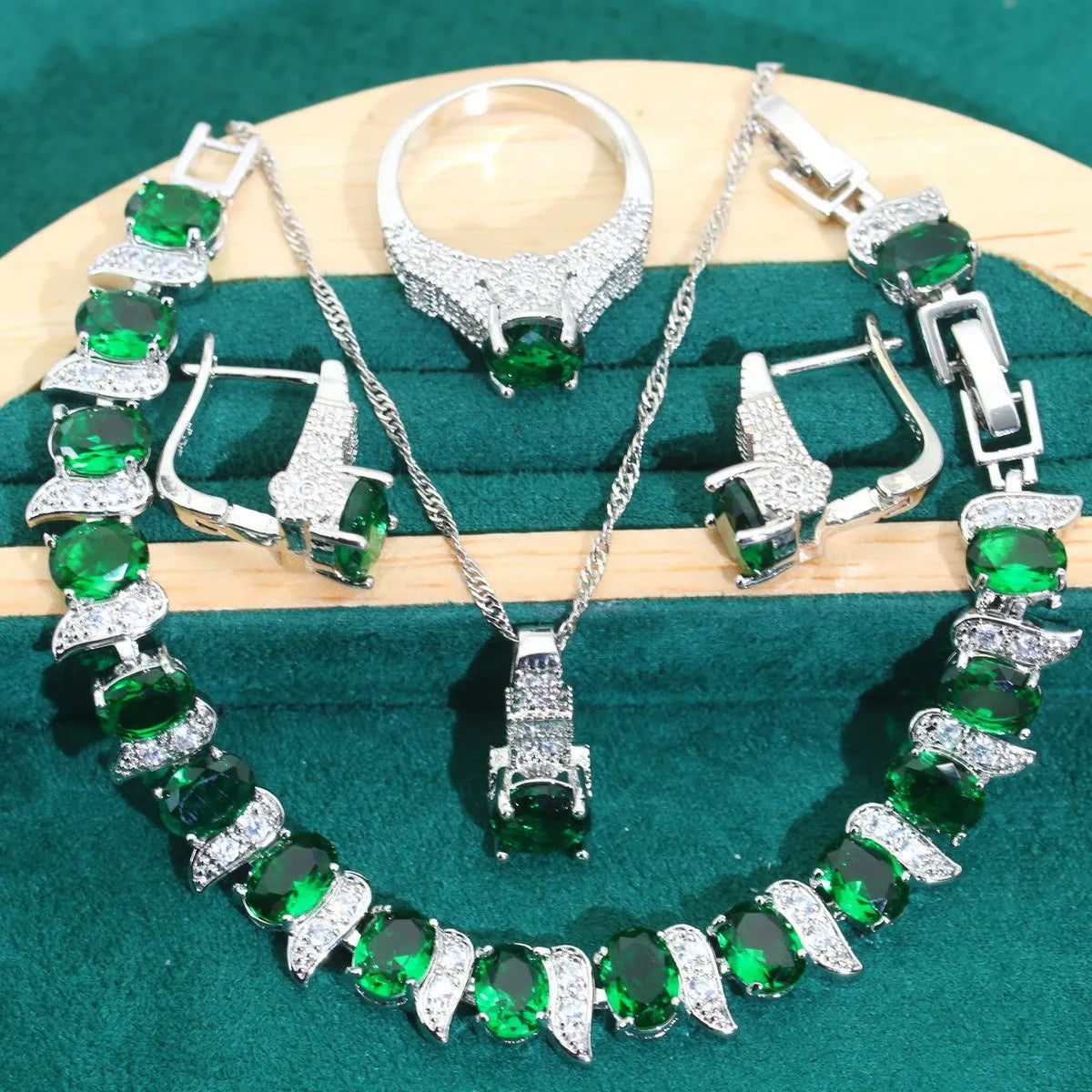 Four-piece bridal jewellery set showing zirconium alloy necklace, earrings, ring, and bracelet in water wave chain design.