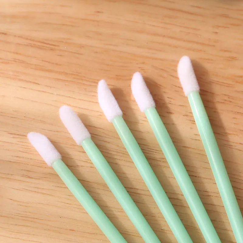Pack of disposable lip brush applicators with coloured handles and flocked brush tips on a white background