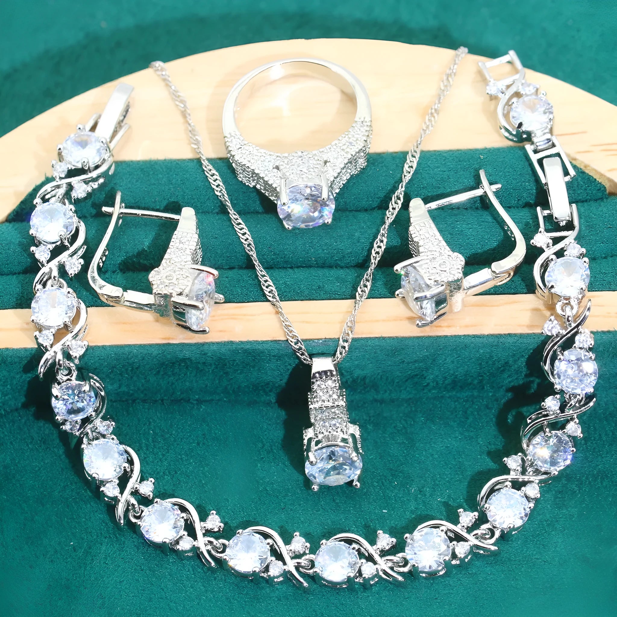 Four-piece bridal jewellery set showing zirconium alloy necklace, earrings, ring, and bracelet in water wave chain design.