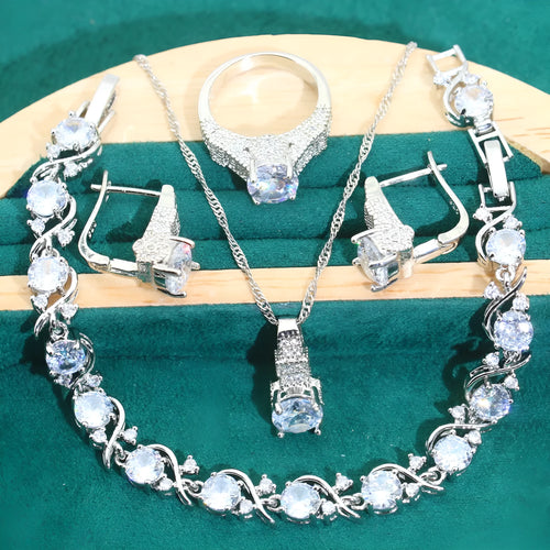 Four-piece bridal jewellery set showing zirconium alloy necklace, earrings, ring, and bracelet in water wave chain design.