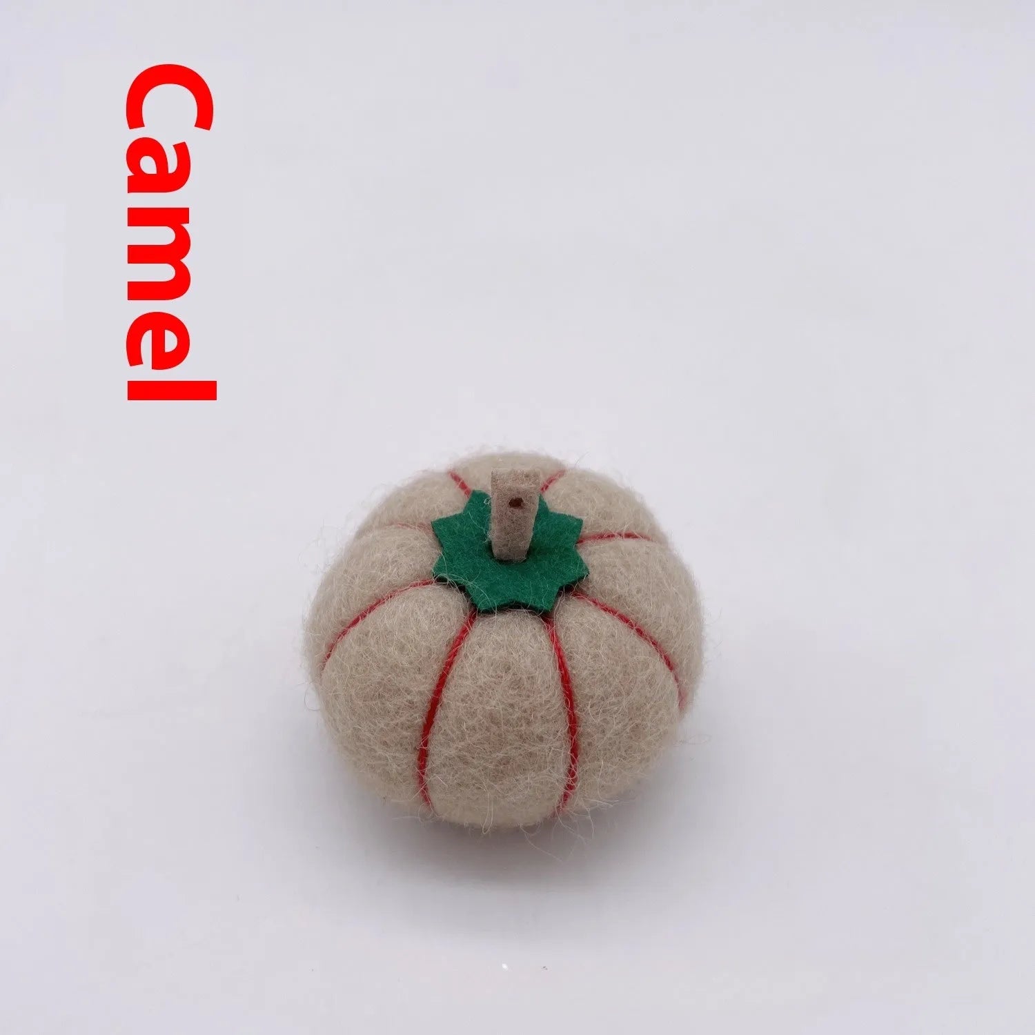 Wool felt pumpkin-shaped doll decorations in autumn colours on a neutral background