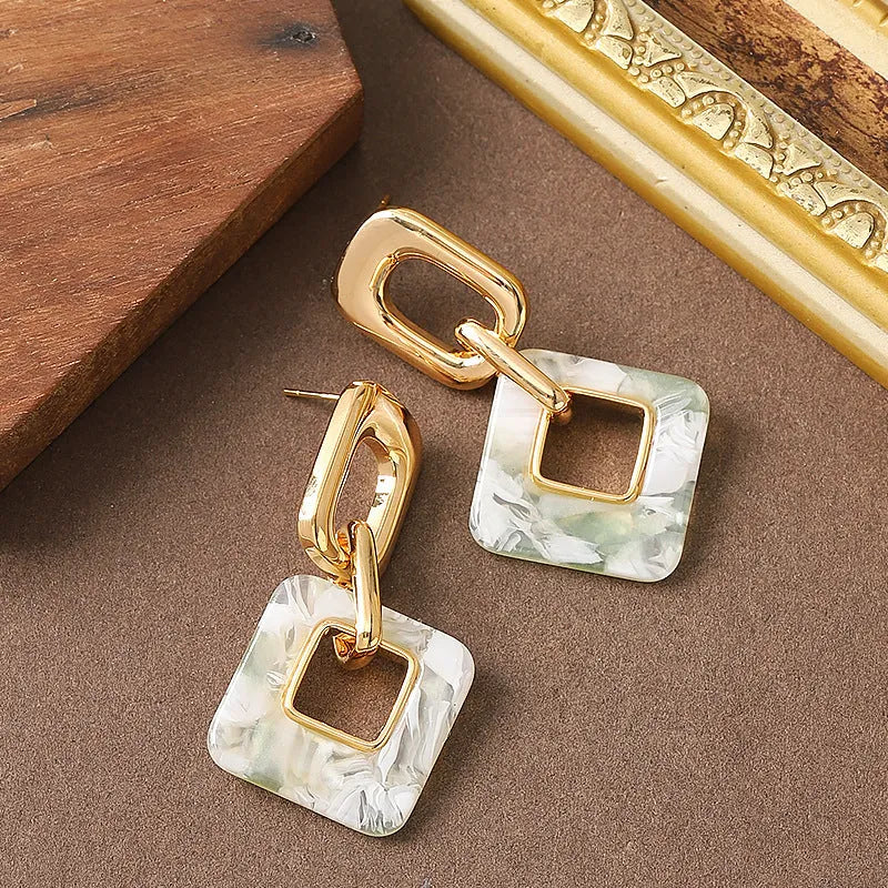 A pair of hollow geometric square earrings with chamfered corners in an electroplated copper finish.