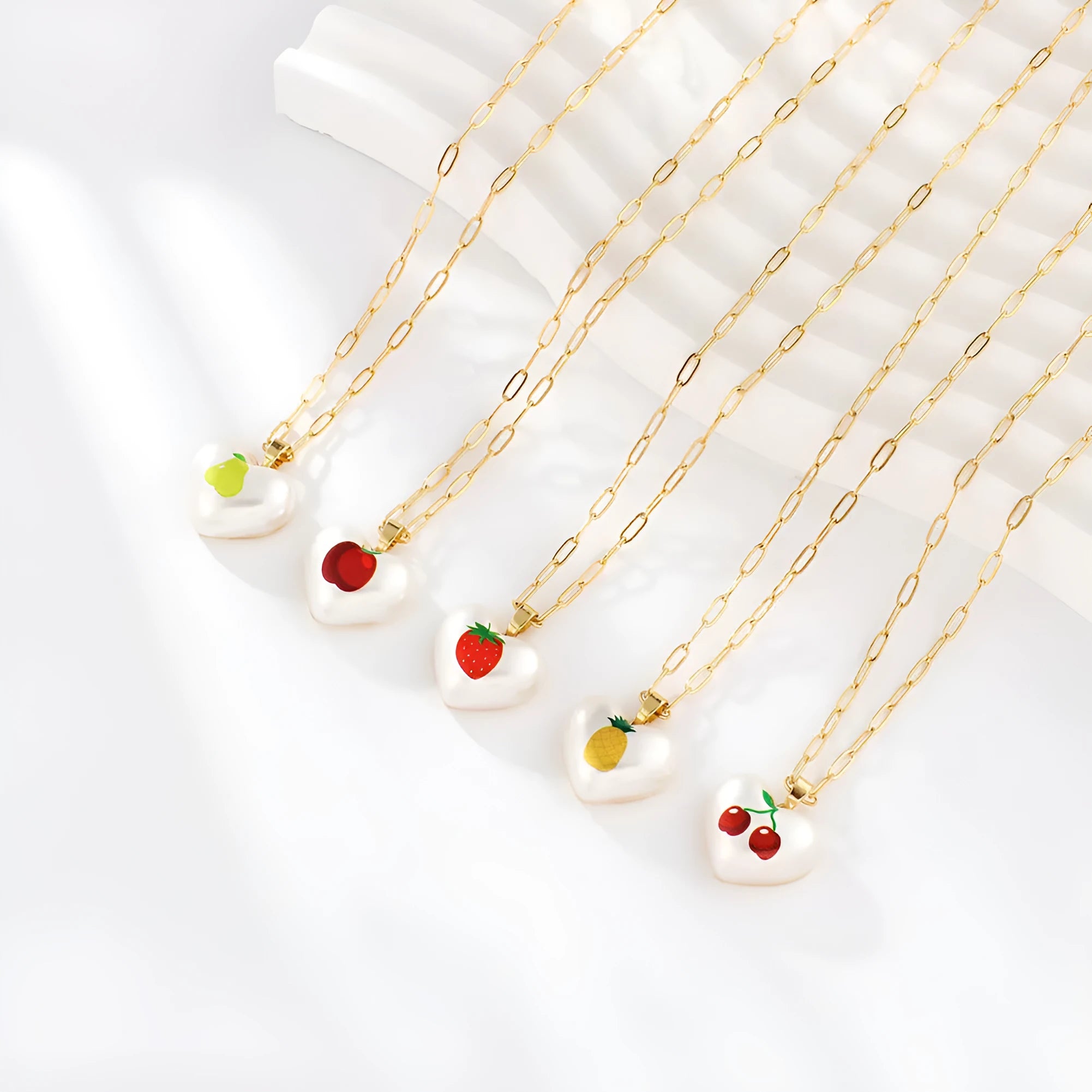 Geometric fruit pendant necklace with adjustable chain showing apple, pineapple, strawberry, cherry and pear designs