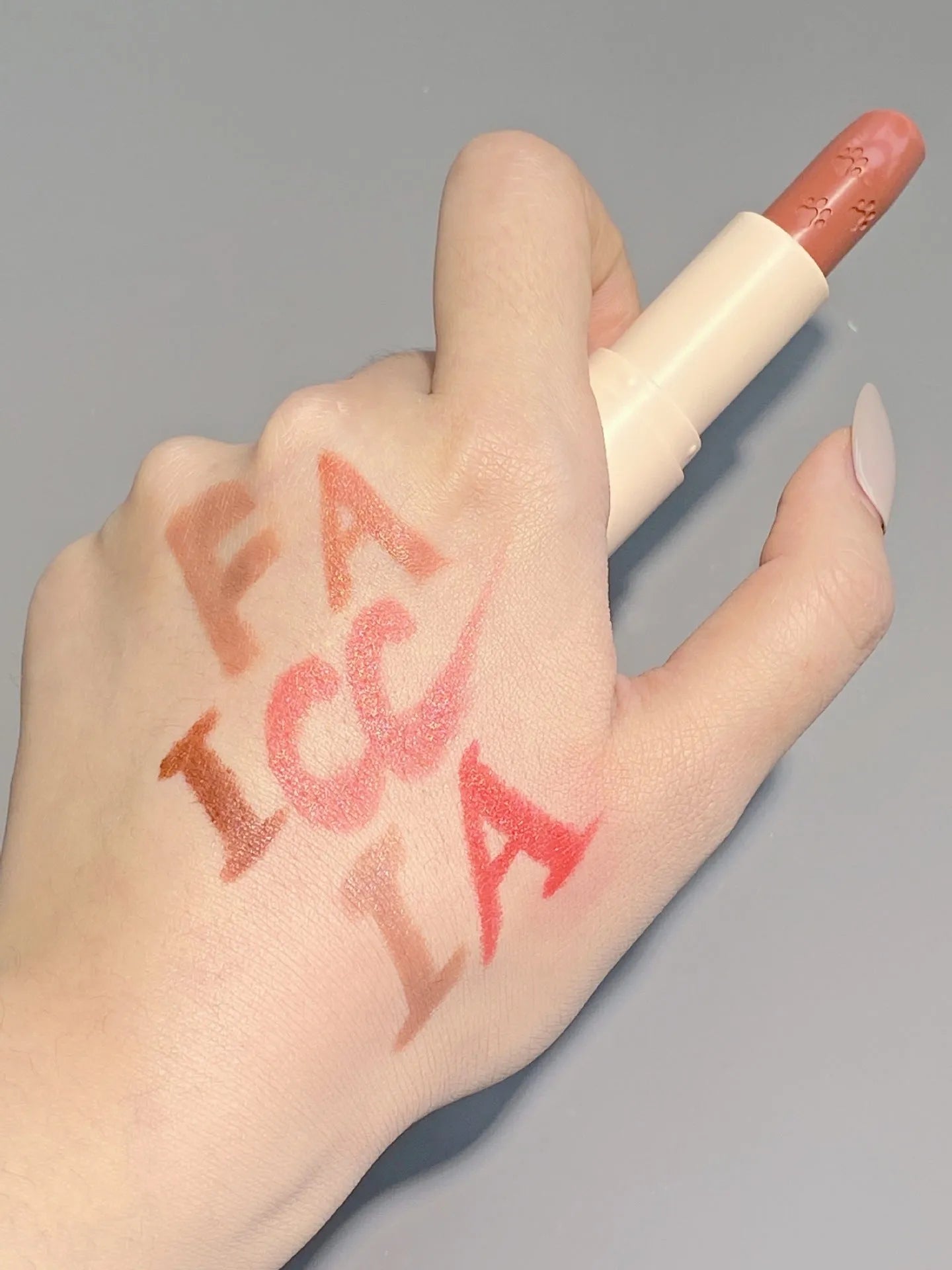 Little white tube matte velvet lipstick with five colour swatches Almond Cinnamon, Amber orange brown, Dirty Orange, Jujube Red Brown, White Peach Bean Paste