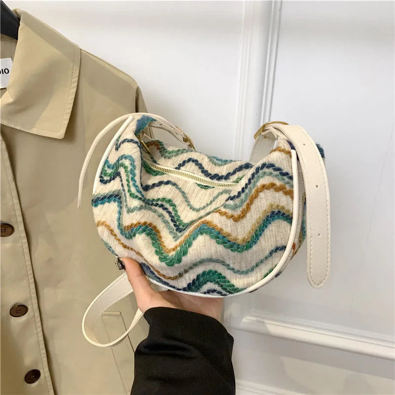 Women's knitted straw woven crossbody bag showing woven texture and internal phone compartment
