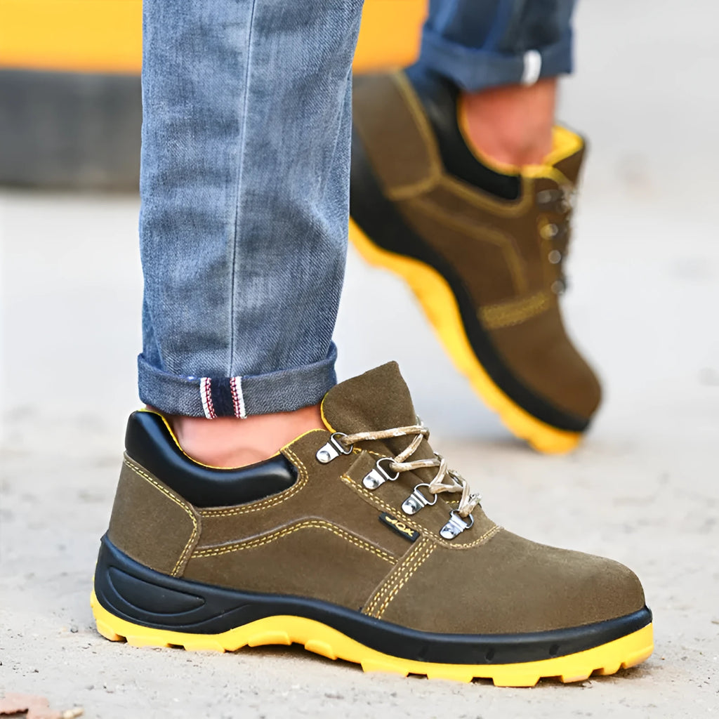 Bronze coloured leather safety boots with steel toe cap on a work site background
